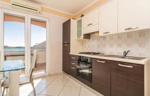 a kitchen with a sink and a stove at 2 Bedroom Stunning Apartment In Povljana in Povljana