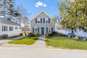 une maison grise avec une porte bleue dans une rue dans l'établissement Mill Cove Cottage, à Boothbay Harbor