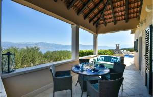 a patio with a table and chairs and a large window at Gorgeous Home In Postira With Heated Swimming Pool in Postira