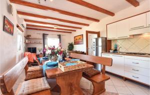 a kitchen with a table and chairs in a room at Gorgeous Home In Postira With Heated Swimming Pool in Postira