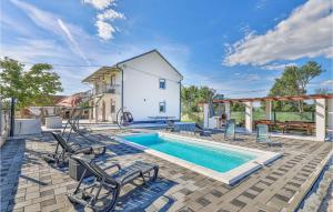 una piscina con sillas y una casa en Beautiful Home In Drnis With Outdoor Swimming Pool en Drniš