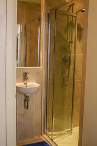 uma casa de banho com um chuveiro e um lavatório. em Blades Hotel em Londres