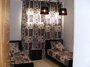 Appartement Hamria Meknes في مكناس: غرفة معيشة مع أريكة وستارة