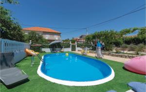 Stunning Apartment In Zadar With Outdoor Swimming Pool في زادار: مسبح ازرق كبير في ساحة