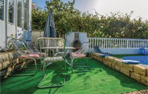 a group of chairs and an umbrella on the grass at Awesome Apartment In Zadar With Wifi in Zadar