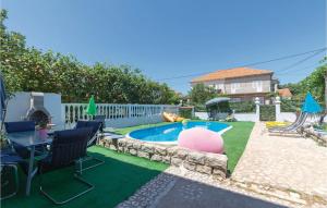 a backyard with a pool with a table and chairs at Awesome Apartment In Zadar With Wifi in Zadar