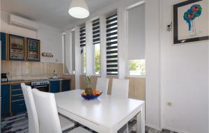 a kitchen with a white table and white chairs at Stunning Apartment In Zadar With Outdoor Swimming Pool in Zadar