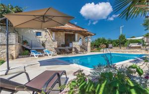 a villa with a swimming pool and an umbrella at 4 Bedroom Cozy Home In Puzari in Pićan