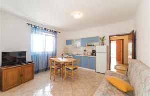 a kitchen and living room with a table and a couch at 2 Bedroom Lovely Apartment In Kustici in Kustići