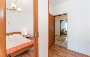 a small bedroom with a bed and a mirror at 2 Bedroom Lovely Apartment In Kustici in Kustići