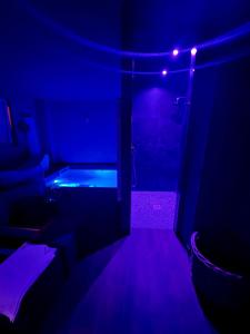 Habitación oscura con bañera y luces púrpuras. en Hotel Bella Napoli ristorante & spa, en Foggia