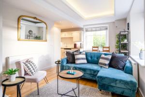 sala de estar con sofá azul y mesa en Stunning 2 Bedroom Apartment in Converted Chapel en Bath