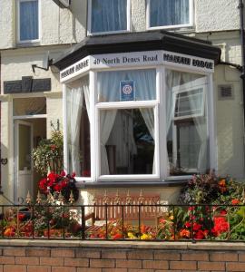 a building with a balcony with flowers on it at Maluth Lodge in Great Yarmouth