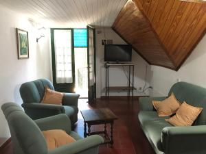 a living room with two chairs and a tv at Zorzal 2 in Puerto Rico