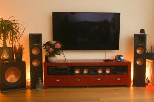 a entertainment center with two speakers and a television at Beautiful quiet family-apartment near The Hague in Rijswijk
