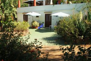 a house with two umbrellas and a table and chairs at Casa Terranova in Ustica