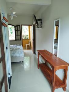 Habitación con mesa de madera y cama en Suíte na Montanha, en Trindade