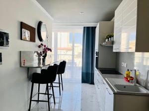 uma cozinha com uma mesa e cadeiras e um lavatório em Apartments by Sliema promenade and beach em Sliema