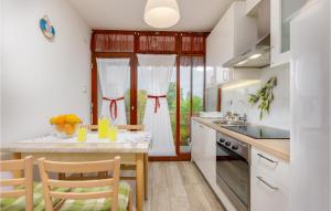 - une cuisine avec une table, des chaises et un comptoir dans l'établissement Cozy Apartment In Malinska With Wifi, à Malinska