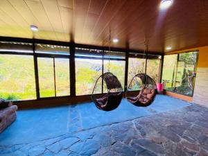 two swings hanging in a room with windows at Rainbow Valley Lodge Costa Rica in Monteverde Costa Rica
