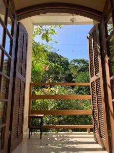 uma porta aberta para uma varanda com vista em Suíte na Montanha em Trindade
