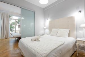 1 dormitorio blanco con 1 cama grande y 1 silla en Promenade, 2pièces chic et clim avec terrasse, en Niza