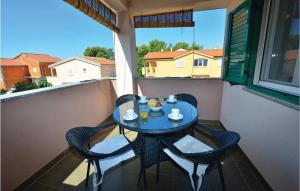 a small table and chairs on a balcony at Awesome Apartment In Privlaka With Kitchen in Batalaži