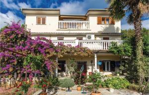 a house with flowers in front of it at Gorgeous Apartment In Medveja With House Sea View in Medveja