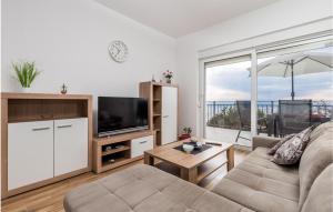 uma sala de estar com um sofá e uma televisão em Lovely Apartment In Bregi With House Sea View em Opatija