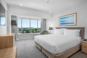 a bedroom with a large bed and a large window at Rydges Rotorua in Rotorua