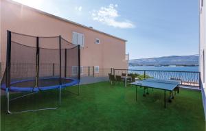 a patio with a trampoline and a table and chairs at Nine-Bedroom Holiday Home In Arbanija in Trogir