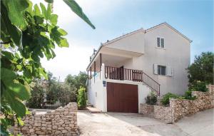 a white house with a gate and a stone wall at Stunning Apartment In Kanica With House Sea View in Sevid