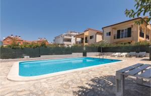 a swimming pool in a yard next to a building at Beautiful Home In Volme With Kitchen in Banjole