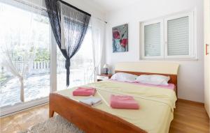 a bedroom with a bed with pink pillows and a window at Two-Bedroom Apartment In Klek in Klek