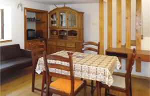 ノヴィ・ヴィノドロスキーにあるAwesome Home In Novi Vinodolski With Kitchenのダイニングルーム(テーブル、キャビネット付)