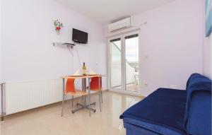 a living room with a table and a blue couch at Beautiful Apartment In Kornic With Kitchen in Kornić