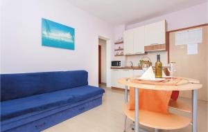 a living room with a blue couch and a table at Beautiful Apartment In Kornic With Kitchen in Kornić