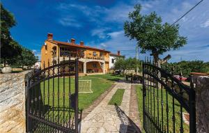 a gate in front of a house with a building at 2 Bedroom Lovely Apartment In Orbanici in Orbanići