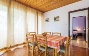 a dining room with a table and chairs and a bedroom at 3 Bedroom Beautiful Apartment In Krk in Krk