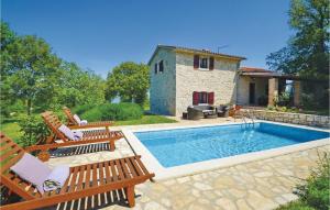 a villa with a swimming pool in front of a house at Beautiful Home In Gondolici With 3 Bedrooms, Wifi And Outdoor Swimming Pool in Labin