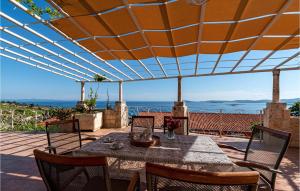 un patio con mesa y sillas bajo una pérgola en Two-Bedroom Holiday Home In Mokalo, en Orebić