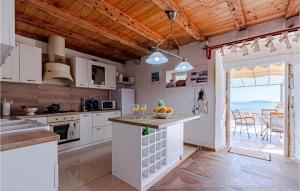 cocina con armarios blancos y vistas al océano en Two-Bedroom Holiday Home In Mokalo, en Orebić
