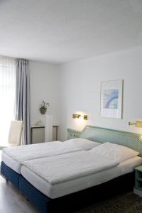 ein Schlafzimmer mit einem großen Bett in einem Zimmer in der Unterkunft Hotel Lauterbach Auf Rügen in Lauterbach