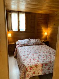 1 dormitorio con 1 cama en una cabaña de madera en CAMPING PUIGCERCOS, en Borredá
