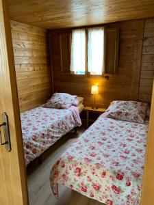 um quarto com 2 camas num chalé de madeira em CAMPING PUIGCERCOS em Borredá