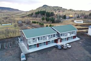 una vista aerea di una casa con auto parcheggiate in un parcheggio di Nortia Apartments a Flúðir