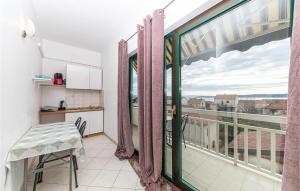 Cette chambre dispose d'un balcon avec une table et une fenêtre. dans l'établissement Gorgeous Apartment In Kastel Stafilic With Wifi, à Kaštela