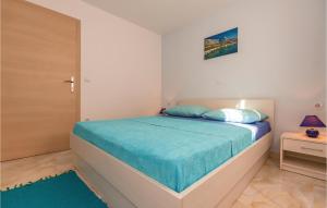 1 dormitorio con 1 cama con colcha azul en Amazing Apartment In Baska Voda With Wifi, en Baška Voda