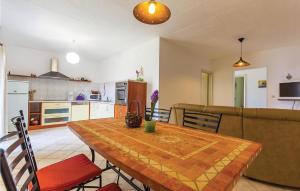 a kitchen and dining room with a table and a couch at Cozy Apartment In Medulin With Wifi in Medulin