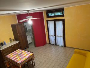 uma sala de estar com uma mesa e uma parede amarela e vermelha em Villetta a schiera in villaggio Metatur em Metaponto
